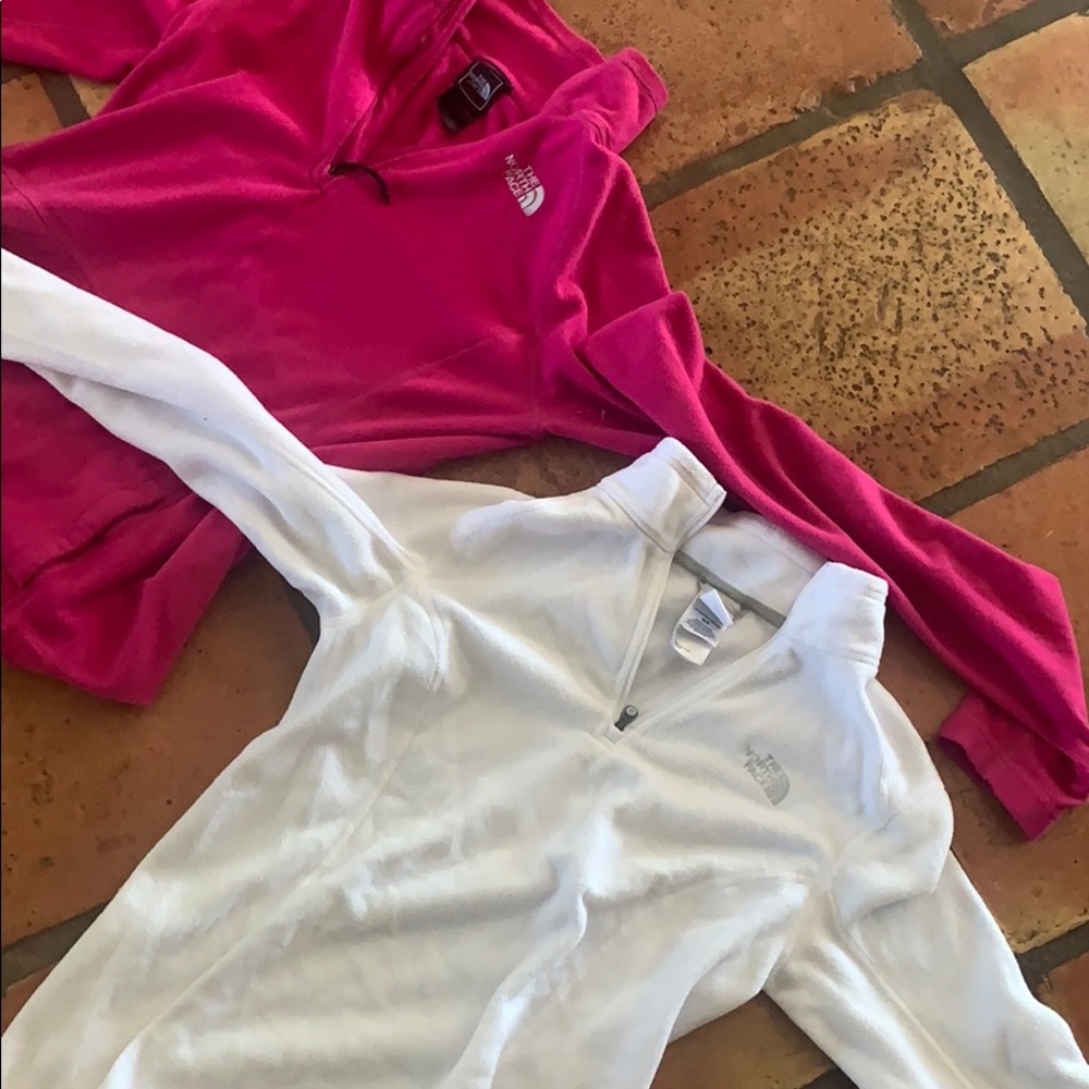 Pink and white north face pull over jackets.